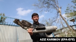 AZERBAIJAN -- A man shows remnants of a missile after allegedly Armenian shelling in the village of Baharli in the Agdam region, 15 October 2020.