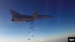 A still image taken from video footage released by Russia's Defense Ministry shows a long-range bomber based in Iran dropping bombs over an unknown location in Syria.