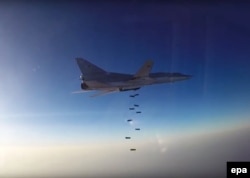 A still image taken from video footage released by Russia's Defense Ministry shows a Russian Tupolev Tu-22M3 long-range bomber based in Iran dropping off bombs at an unknown location in Syria.