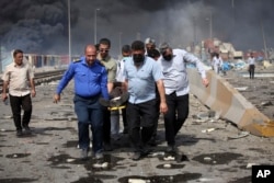 People carry an injured man following the April 26 explosion.