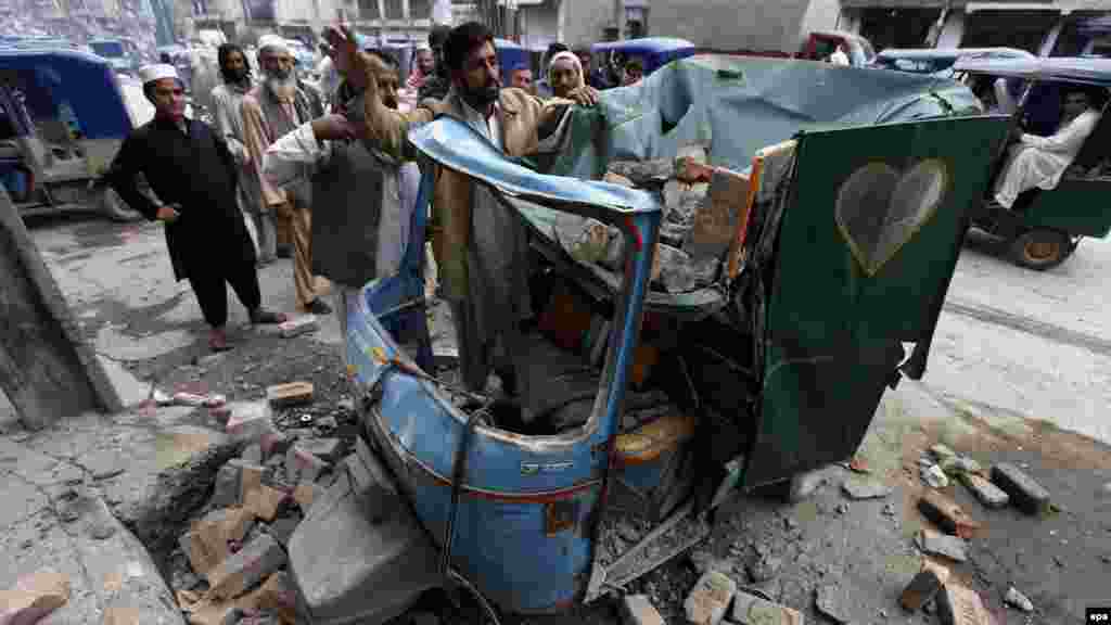 Люди прибирають сміття з рікші в Пешаварі, Пакистан