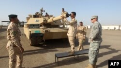 عسكريون أميركيون وعراقيون يدربون جنوداً على استخدام دبابة في معسكر التاجي
