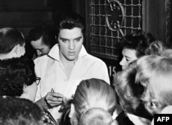 Элвис Пресли күйөрмандарынын курчоосунда. Голливуд, 1958-жыл.