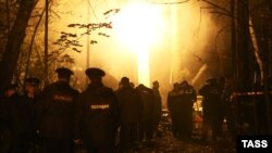 Russian Emergency Situations Ministry workers and rescuers inspect the site of a helicopter crash in the Lyubertsy district near Moscow early on September 22.