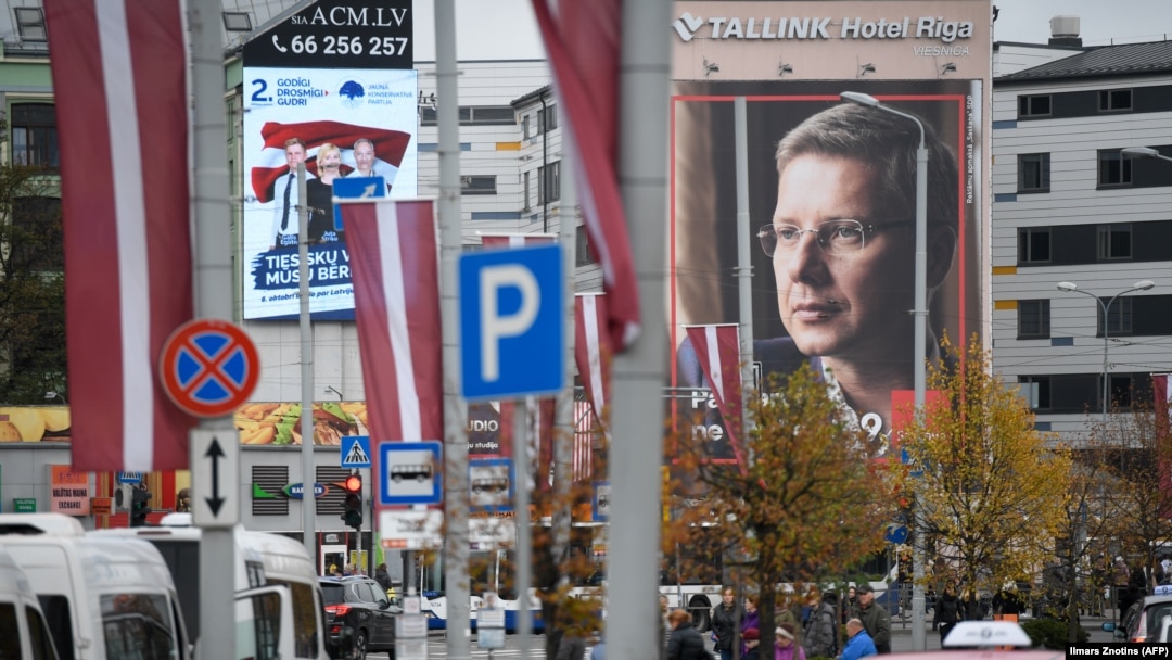 Lider proruske orijentisane partije Harmonija Nils Usakovs na plakatu (desno) i lideri Nacionalne Alijanse na plakatu (lijevo) u Rigi, Letonija