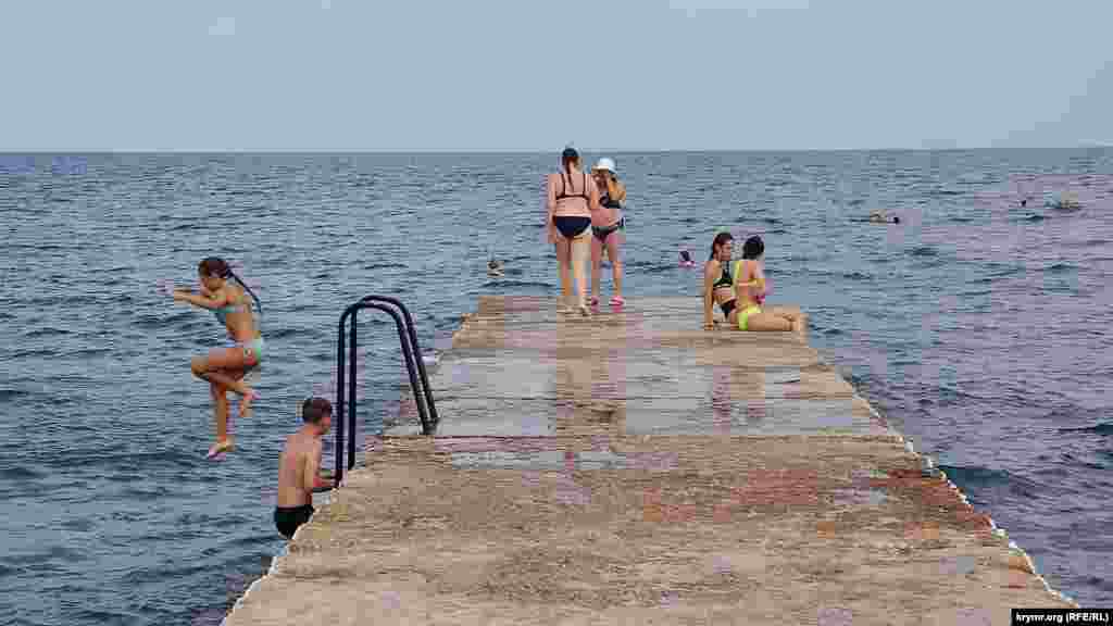 Дети охотно прыгают с буны в море, что запрещено на пляже