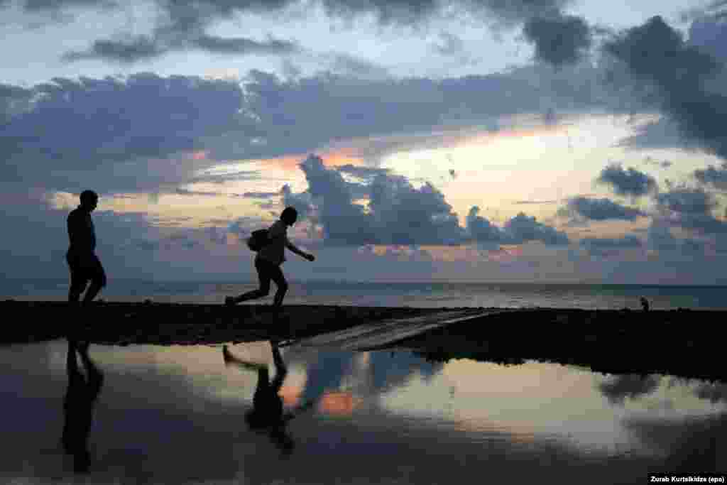 People walk on a Black Sea beach at sunset in Batumi, Georgia. (epa/Zurab Kurtsikidze)