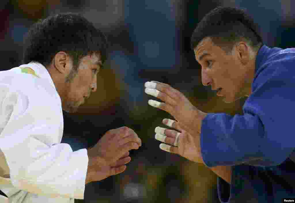 Yeldos Smetov (left) of Kazakhstan and Diyorbek Urozboev of Uzbekistan compete in the men&#39;s 60-kilogram judo competition.