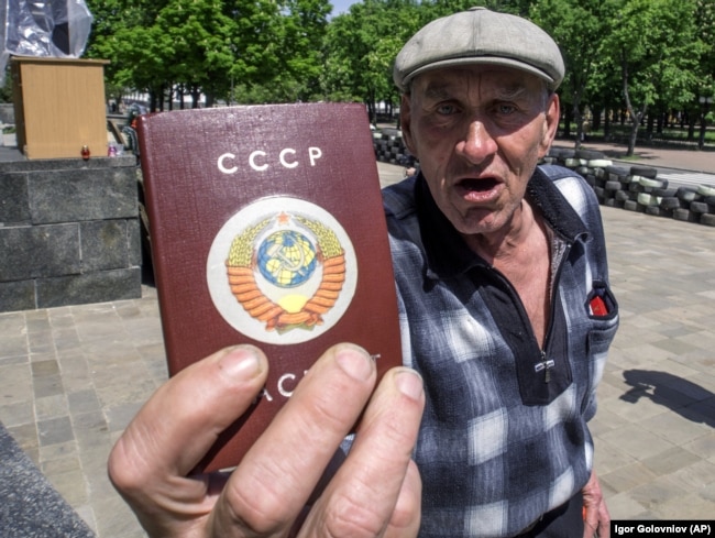 Чоловік демонструє паспорт, на обкладинці якого напис СРСР і колишній радянський герб. Луганськ, 10 травня 2014 року
