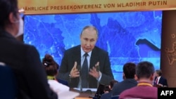 Journalists watch Russian President Vladimir Putin during his annual press conference, via video link from the Novo-Ogaryovo state residence, in Moscow on December 17, 2020.