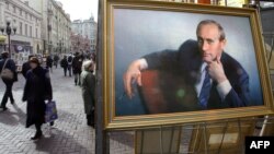 Люди проходят мимо портрета президента России Владимира Путина на улице Арбат. Москва, 12 марта 2004 года.