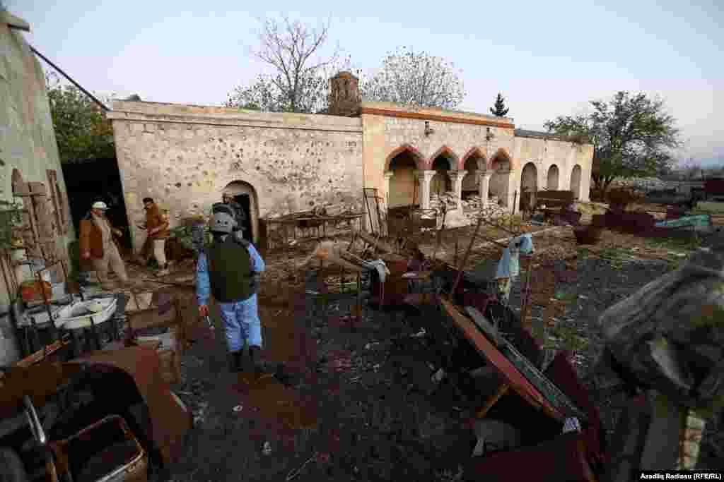 An Azerbaijani soldier carries out demining work amid damaged historical buildings in Agdam.