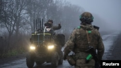 Військовослужбовці 93-ї окремої механізованої бригади ЗСУ «Холодний Яр» вітаються з побратимом після повернення з бойового завдання, поблизу Костянтинівки в Донецькій області, 27 листопада 2025 року