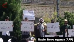 An Iranian cleric speaks to a crowd of protesters demonstrating in the city of Mashhad, in the Khorasan Razavi province, on August 3.