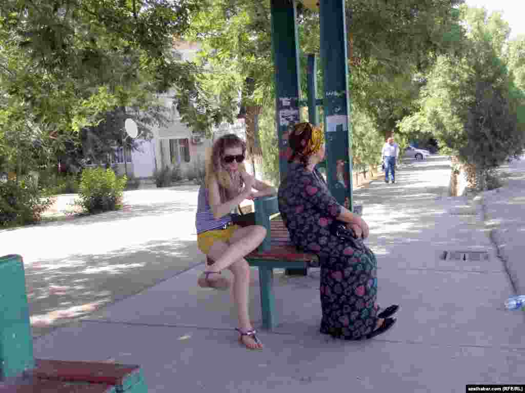 Awtobusa garaşyp oturan ýolagçylar 