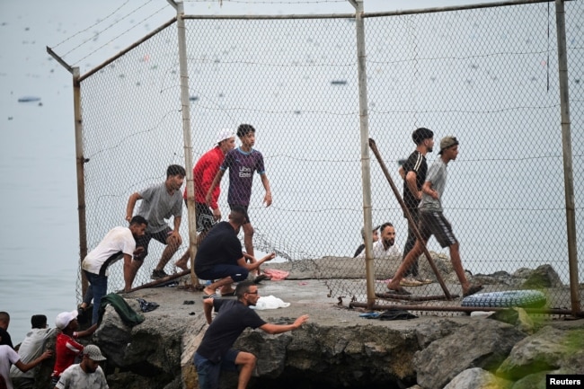 Migrantët hynë në Spanjë nga Maroku si përmes rrugës tokësore, ashtu edhe asaj detare. Kjo fotografi shfaq migrantët kthehen në Marok nga enklava spanjolle e Ceutas, më 31 korrik 2026.