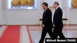 Uzbek President Shavkat Mirziyaev (left) and Russian President Vladimir Putin on their way to a meeting at the Kremlin in Moscow on April 5.