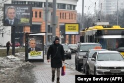 Un om trece în Lviv/Lvov pe lângă afișe electorale cu Andri Sadovi.