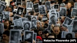 People hold up pictures of those who died in the AMIA Jewish center bombing that killed 85 people as they commemorate the attack's 22nd anniversary in Buenos Aires, Argentina, Monday, July 18, 2016. File photo