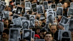مردم تصاویر قربانیان انفجار مرکز یهودیان آرژانتین را در دست گرفته‌اند.
