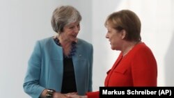 GERMANY -- German Chancellor Angela Merkel, right, and British Prime Minister Theresa May shake hand prior to a meeting in the chancellery in Berlin, Germany, Thursday, July 5, 2018.