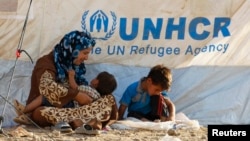 Syrian refugees rest at a new refugee camp on the outskirts of the city of Irbil, in Iraq's Kurdistan region.