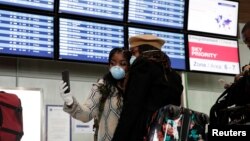 Pasagjerë me maska brenda një aeroporti në Paris të Francës. 