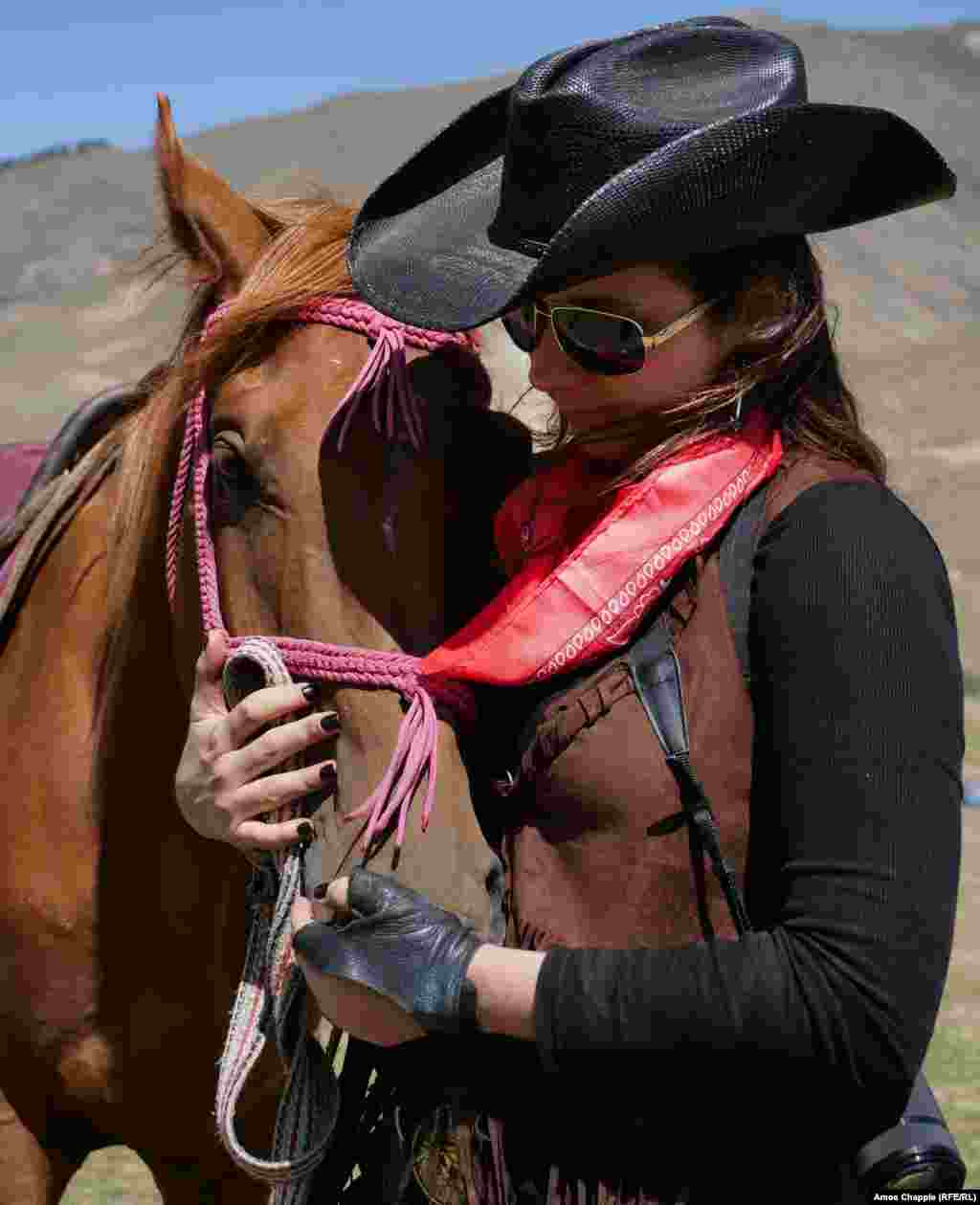 Texan Susannah Winfield comforts her horse before the event. Winfield told RFE/RL there was some head scratching among the U.S. contingent over what exactly America&#39;s traditional dress was: &quot;I think a lot of [Kyrgyz] people thought we would compete in native American clothing, but we had to explain that we can&#39;t really do that, and we figured the cowboy look would be less controversial.&quot;