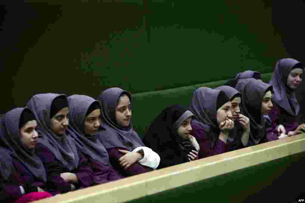 Iranian schoolgirls observe members of parliament discussing a draft bill that would limit photographers&#39; access to cover parliament&#39;s open sessions in Tehran. (AFP/Behrouz Mehri)