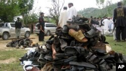 Villagers and officials collect the shoes of participants in the funeral ceremony of an anti-Taliban leader who was targeted in a suicide bombing in Lower Dir in September 2011. (file photo)