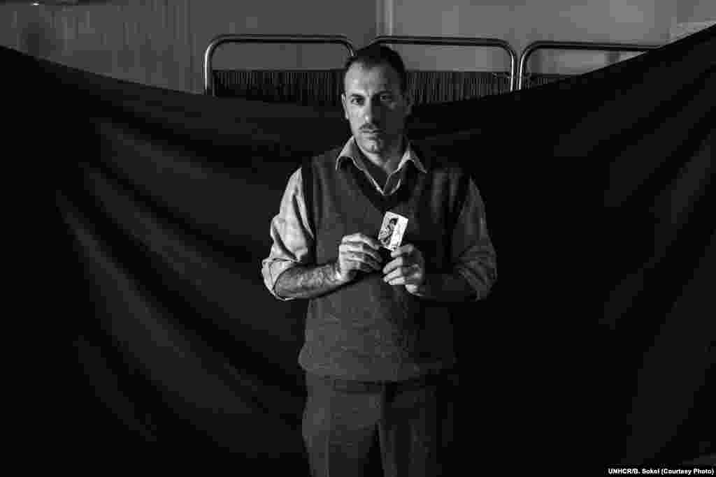 A doctor, Waleed, 37, poses for a portrait in the Médecins Sans Frontières clinic where he works in Domiz refugee camp in the Kurdistan Region of Iraq on 16 November 2012. Waleed fled Syria with his wife and their newborn baby in early 2012. The most important thing that Waleed was able to bring with him is the photograph of his wife that he holds here. Although they are still together, he says, "This is important because she gave me this photo back home before we were married, during the time when we were dating. It always brings me great memories and reminds me of my happiest time back home in Syria.”