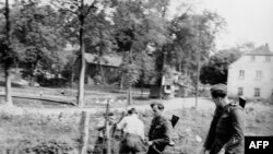 East German border police set up barbed wire along the border between East and West Germany.