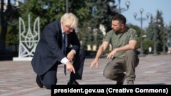 Președintele Ucrainei, Volodimir Zelenski (dreapta), și prim-ministrul britanic demisionar Boris Johnson dezvelesc o placă cu numele lui Johnson pe Aleea Curajului, Kiev, 24 august 2022