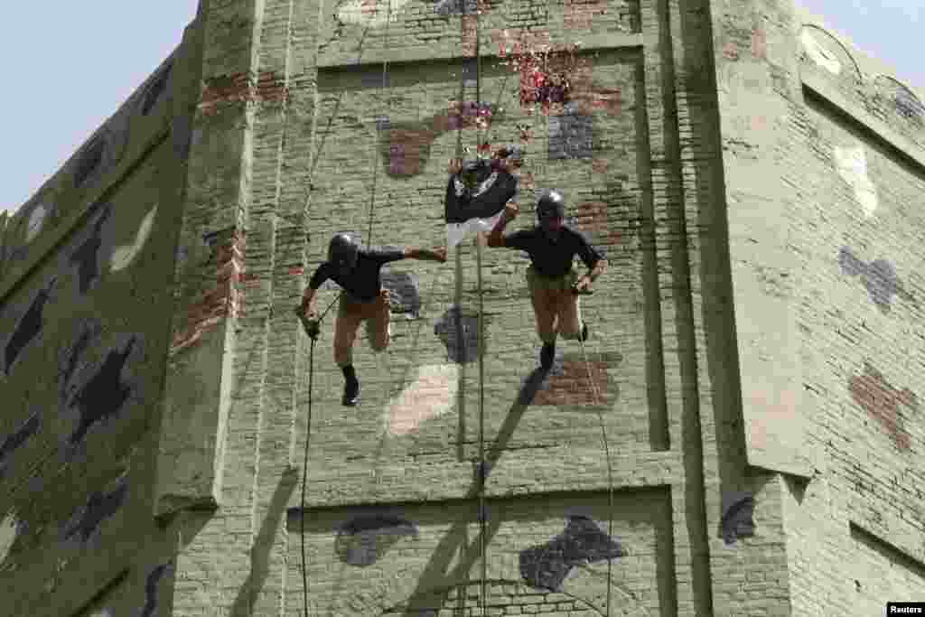 Police commandos display their skills during a passing out parade upon the completion of their three-month training in Lahore on April 28. (Reuters/Mohsin Raza)