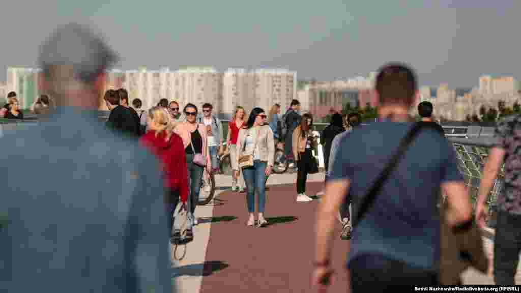 Киевляне прогуливаются по пешеходно-велосипедному мосту, который соединяет пространство возле арки Дружбы народов и Владимирскую горку.