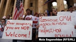 Плакати учасників мітингу – «Дорогі окупанти, вам тут не раді», «Російські ЗМІ – підбурювачі гібридної війни», Тбілісі, Грузія, 20 червня 2019 року