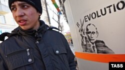 A man walks past a wall in Yekaterinburg painted with graffiti showing Prime Minister and presidential candidate Vladimir Putin.