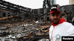 یک عضو هلال‌احمر در کنار خرابه‌های یک تعمیرگاه ماشین در تهران پس از حملات آمریکا و اسرائیل (شنبه ۸ فروردین ۱۴۰۵)