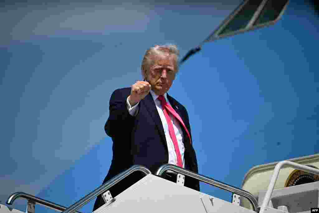 Президент США Дональд Трамп поднимает кулак, садясь на борт самолета "Эйр Форс Уан" на базе Эндрюс в штате Мэриленд 16 апреля 2026 года. Джим Уотсон/AFP