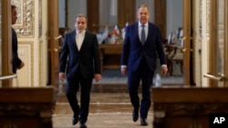 Iranian Foreign Minister Abbas Araghchi (left) and his Russian counterpart, Sergei Lavrov, arrive for their a press conference in Tehran on February 25.