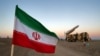 Një flamur iranian afër një rakete gjatë një stërvitje ushtarake, me pjesëmarrjen e njësive të Mbrojtjes Ajrore të Iranit, 19 tetor 2020. 