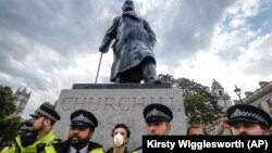 Statuia lui Winston Churchill, păzită de poliție, după ce a fost vandalizată în timpul protestelor antirasiste