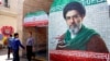 A man walks past a banner depicting Iran's current supreme leader, Ayatollah Mojtaba Khamenei, on a street Tehran on May 6.