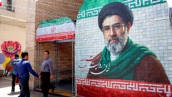 A man walks past a banner depicting Iran's current supreme leader, Ayatollah Mojtaba Khamenei, on a street Tehran on May 6.