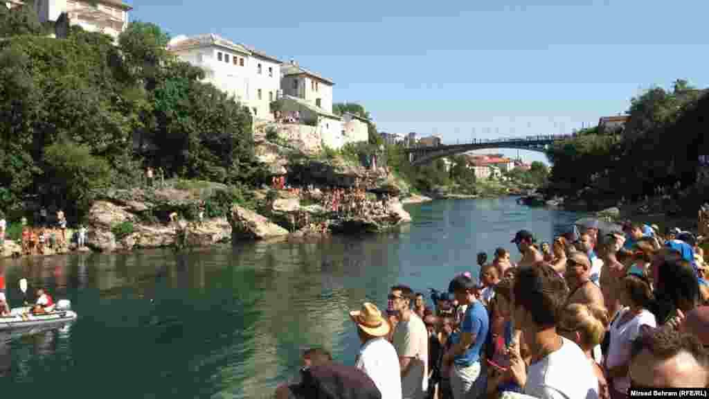 Spectators watch the competition from the riverbank.