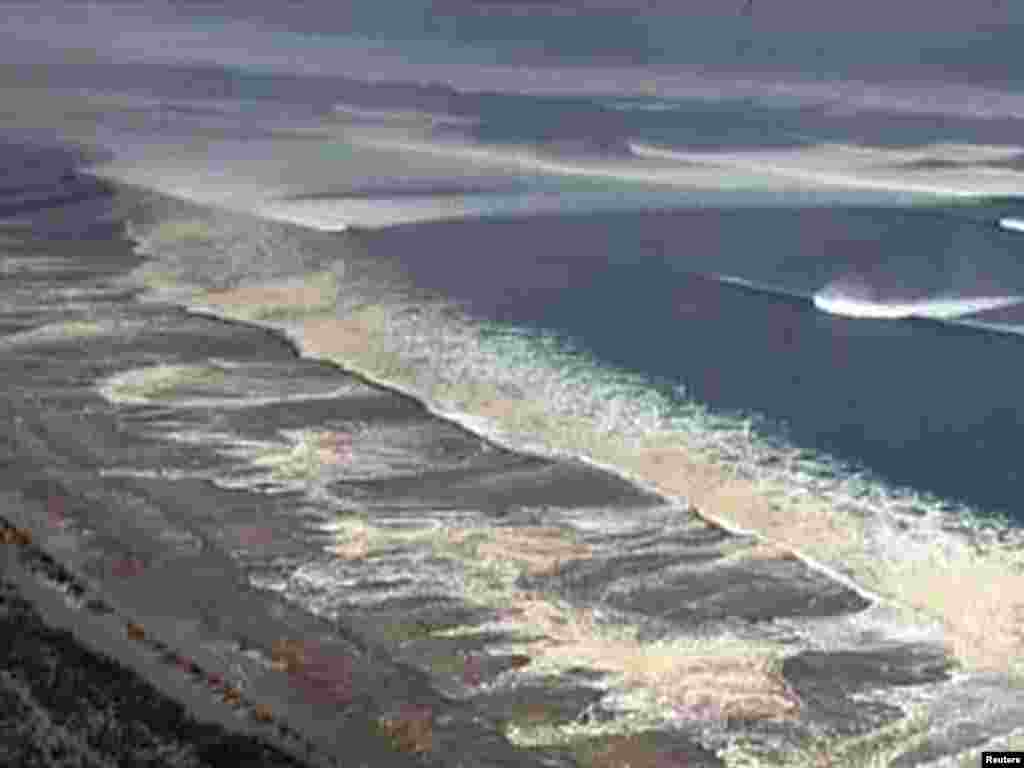 Japan -- Tsunami waters engulf Sendai in this still image taken from video footage, 11Mar2011 - Цунами в Сендае. Скриншот 11 марта 2011. REUTERS/NHK via Reuters TV