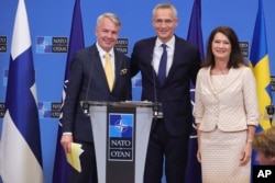 Finland's Foreign Minister Pekka Haavisto (left), Sweden's Foreign Minister Ann Linde (right), and NATO Secretary-General Jens Stoltenberg talks to the media after the signature of the NATO Accession Protocols in Brussels on July 5.