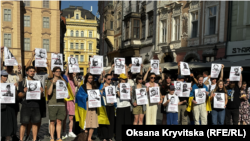 Учасники акції в центрі Праги тримають портрети українських військовополонених, які загинули в Оленівці. 28 липня 2026 року 
