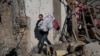 A resident carries out items from their house, which was heavily damaged by a Russian missile strike, on Odesa. 