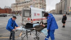 Жедел жәрдем қызметкерлері науқас адамды ауруханаға апара жатыр. Мәскеу, Ресей, 17 сәуір 2020 жыл.